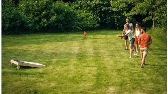 grasveld waarop mensen het cornhole spel spelen